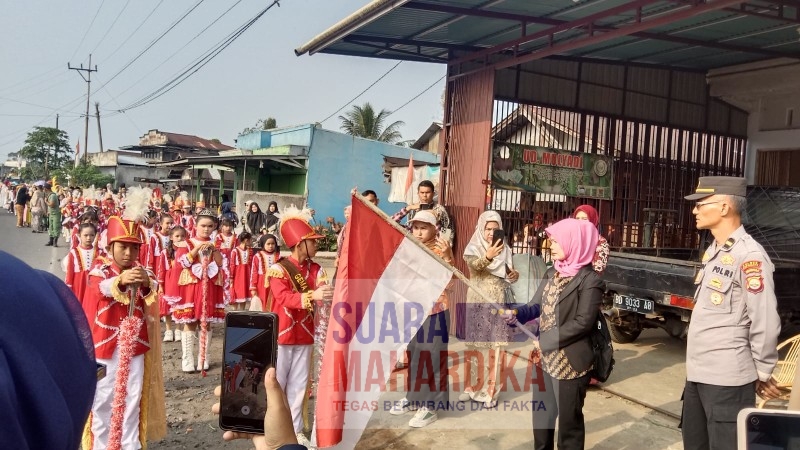 Kepala Desa Pekalongan Saripah Ainun mengibarkan bendera tanda dimulainya Pawai Desa Pekalongan (doc.sma 2024)